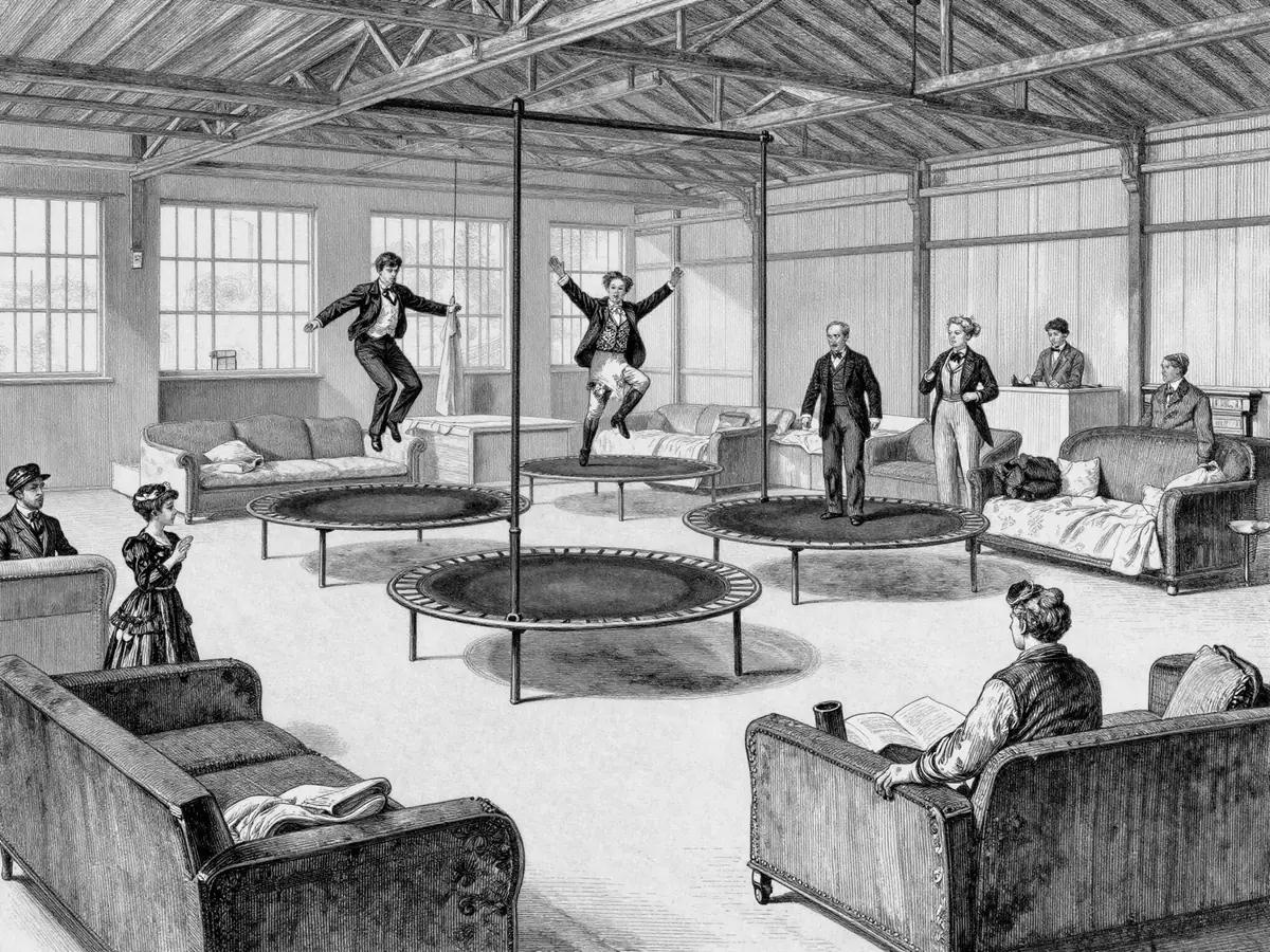 Folk i finklær hopper på trampoliner midt i en møbelhall med sofaer